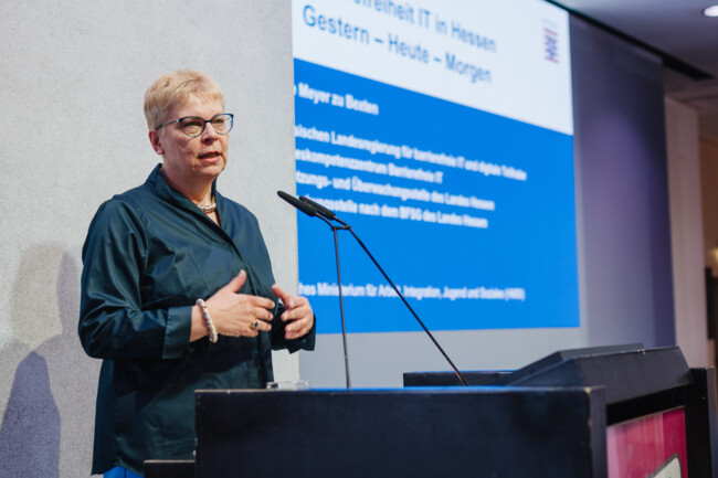 Prof. Dr. Erdmuthe Meyer zu Bexten steht am Redepult. Im Hintergrund ist ihre Präsentation auf der Leinwand zu sehen.