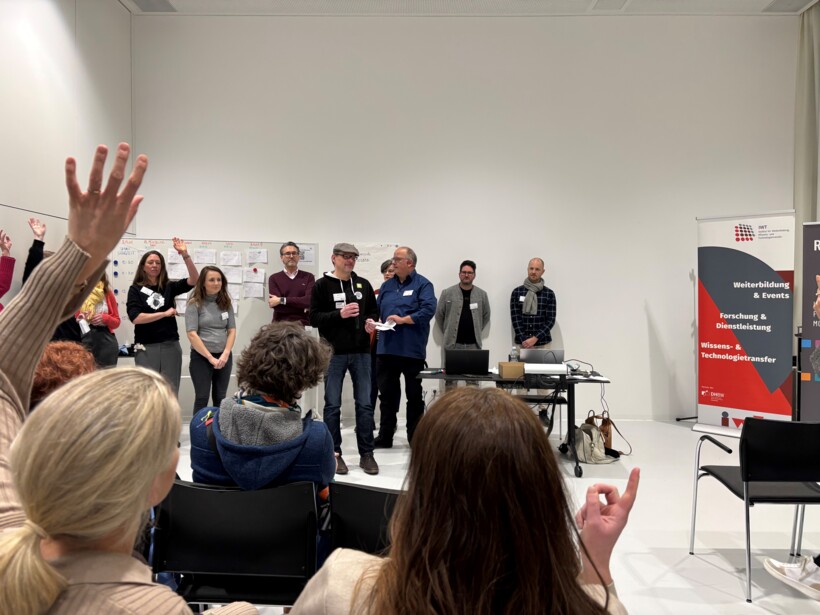 Das gemeinsame Erstellen der Agenda auf dem Barcamp Digitale Barrierefreiheit Bodensee: Markus Erle stellt sein Session Thema vor und Barcamp-Teilnehmer:innen heben ihre Hand, um zu signalisieren, dass sie an diesem Thema interessiert sind.