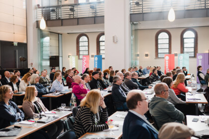 Side view of axes4 Day attendees listening intently to a talk.